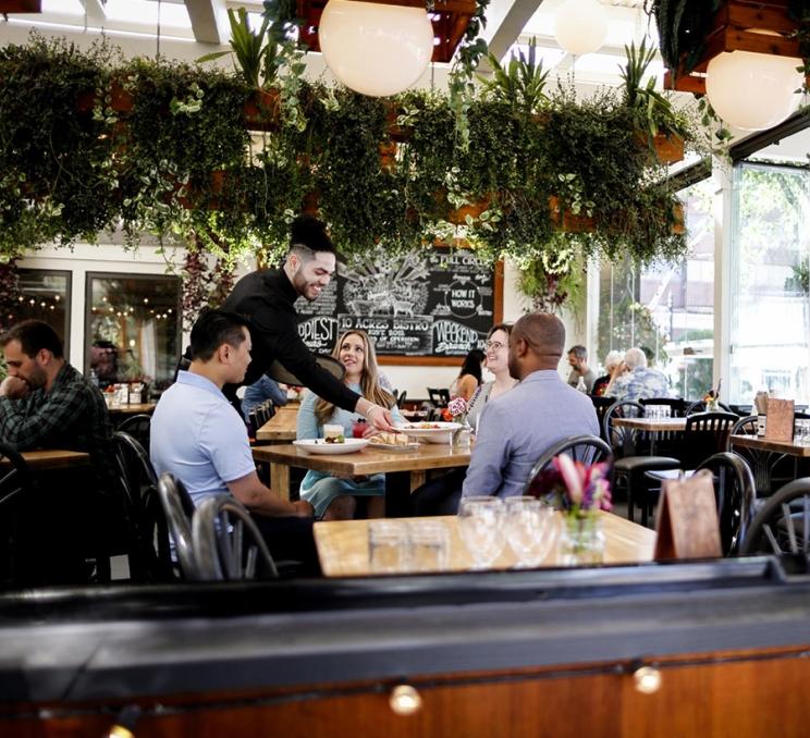 A group dines at 10 Acres Bistro in Victoria, BC