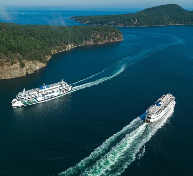 Two BC Ferries vessels sail through a channel separating two of the Southern Gulf Islands off the coast of Victoria, BC