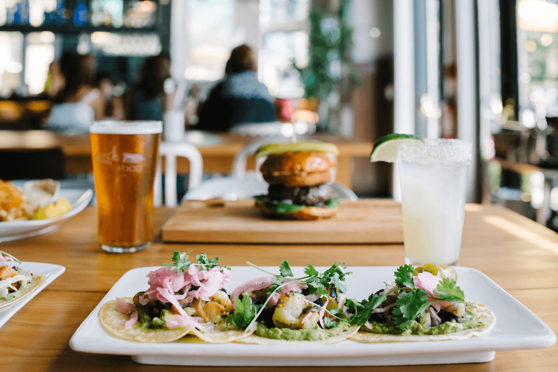 three tacos, a margarita, beer, and burger