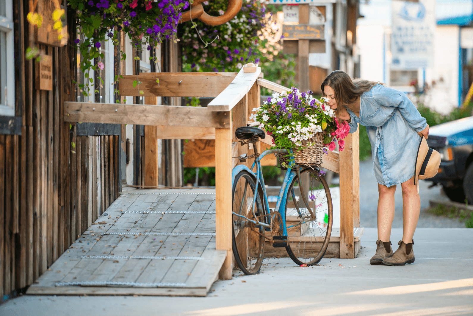 woman smelling flowers planted in a bike basket