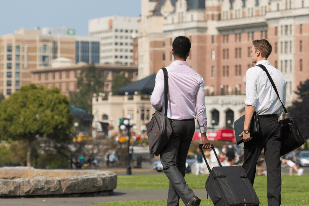 two peopla walking outside with luggage