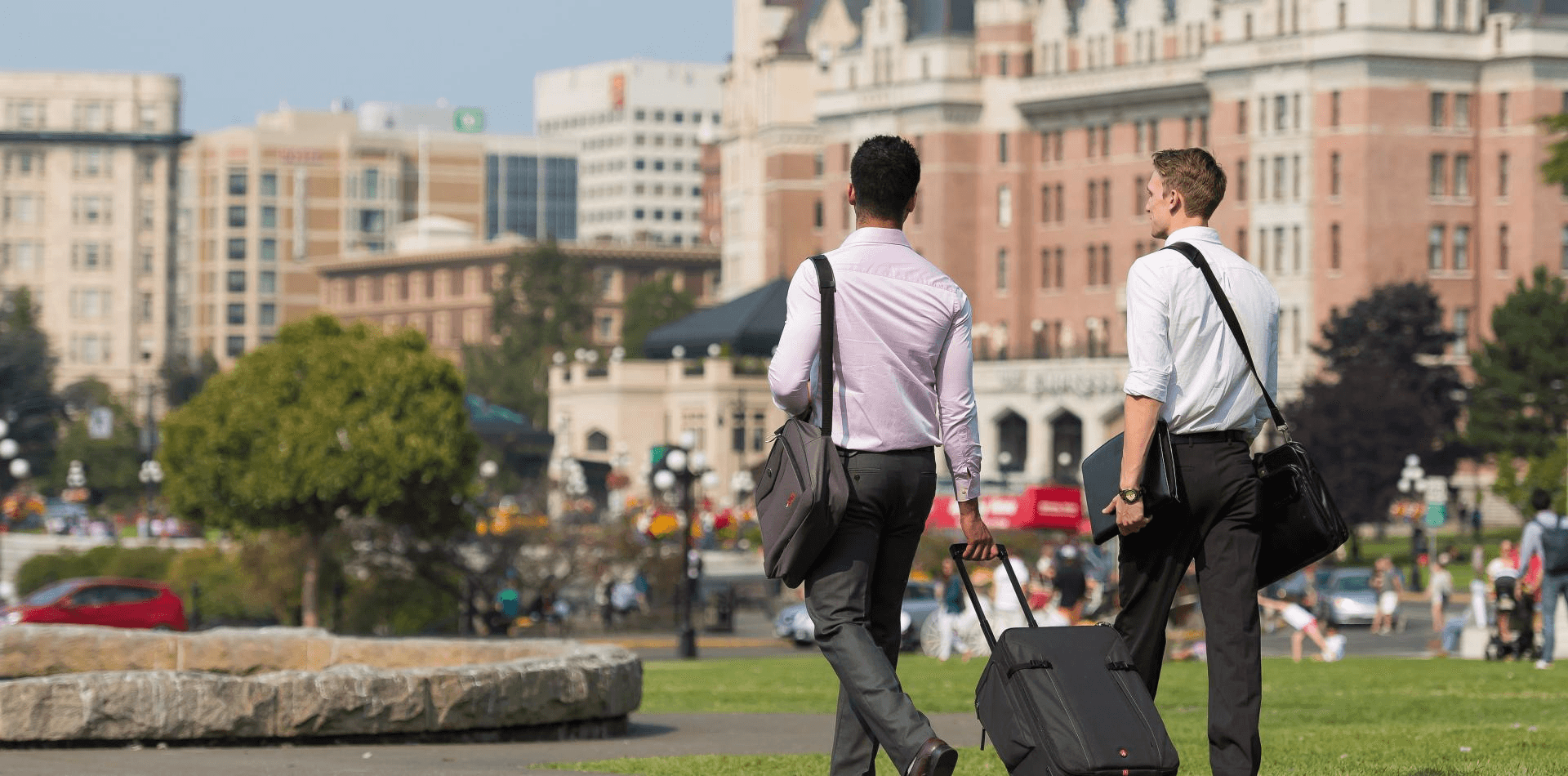 two peopla walking outside with luggage