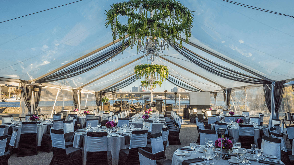 inside a wedding tent, tables and chairs set up for a function