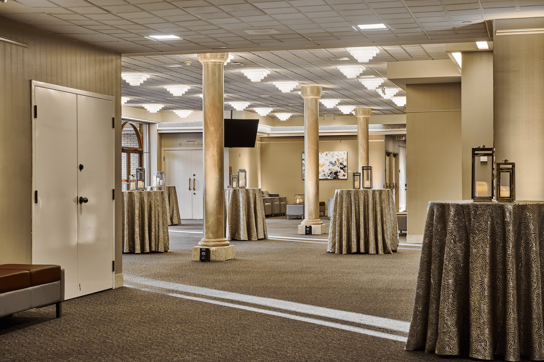 room with standing tables with candles on top