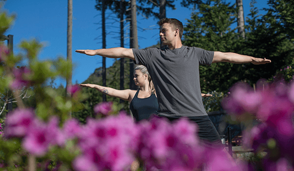 two people doing yoga outside