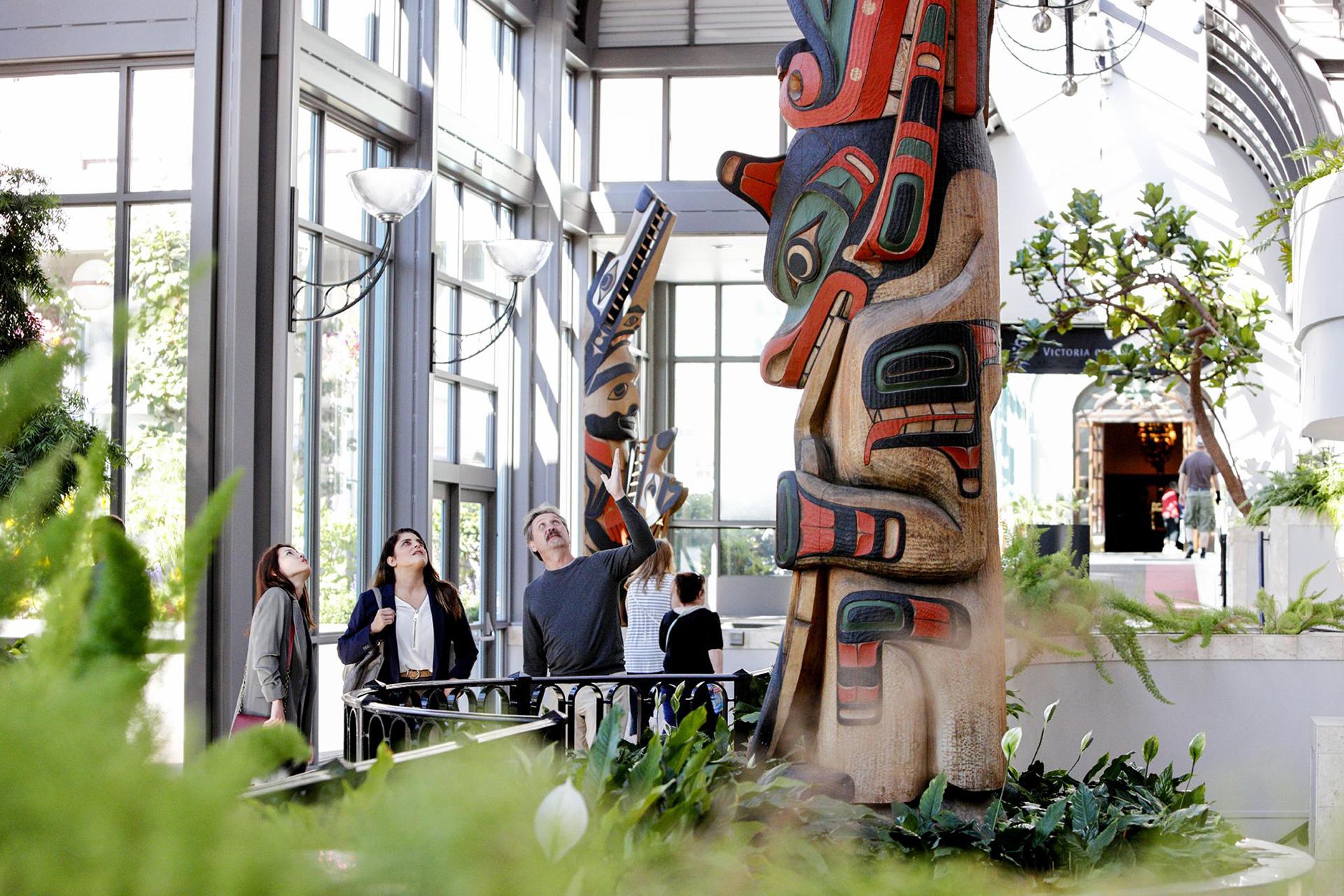 People watching Victoria Conference Centre totem pole