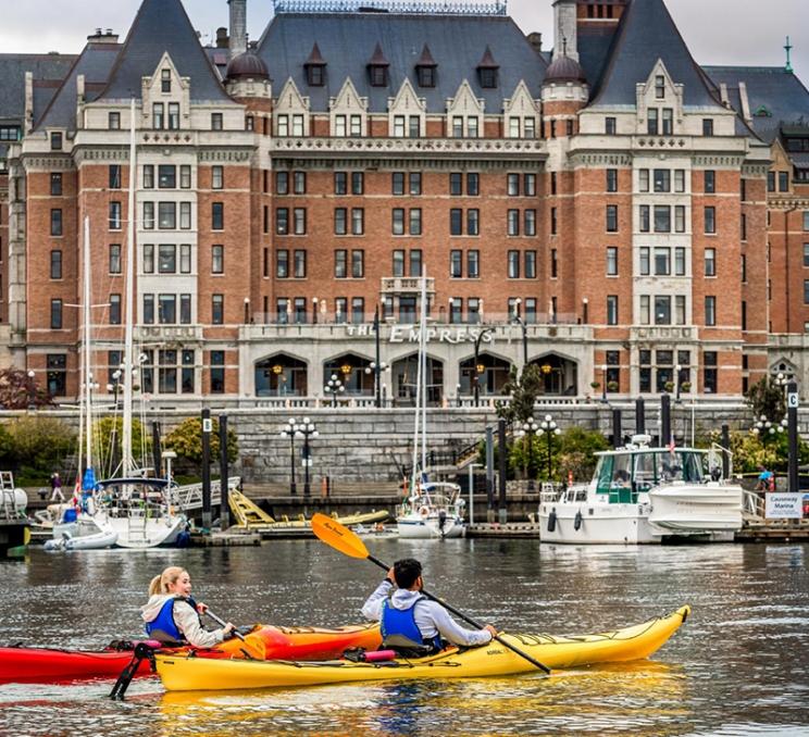 A pair of kayakers paddle past the Fairmont Empress in Victoria, BC