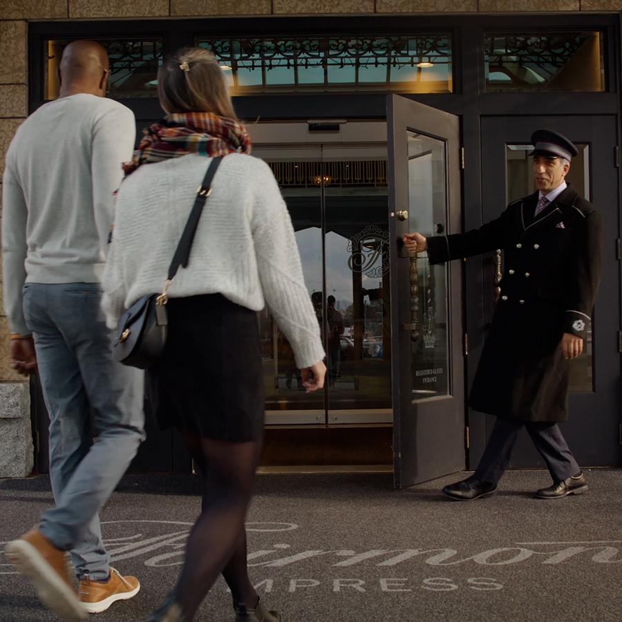 A couple is greeted by a doorman at the Fairmont Empress in Victoria, BC