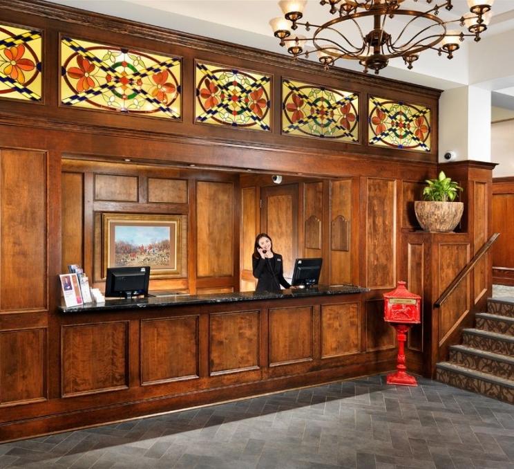 A front desk person works reception at a hotel in Victoria, BC