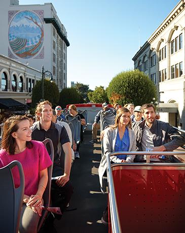 A hop-on hop-off tour bus explores downtown Victoria, BC