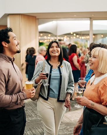 A group socializes over drinks at an event in Greater Victoria