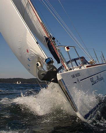 A sailboat cuts across the water in Victoria, BC