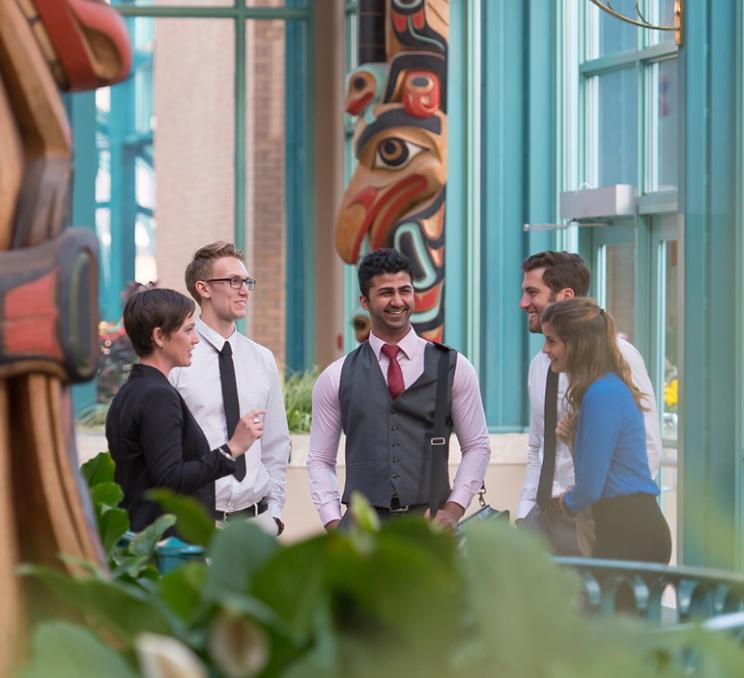 A group of delegates chat at the Victoria Conference Centre in Victoria, BC