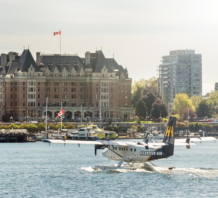A Harbour Air Seaplanes flights lands on Victoria BC's iconic Inner Harbour