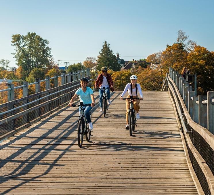A group of friends rides bikes along the Selkirk Trestle in Victoria, BC